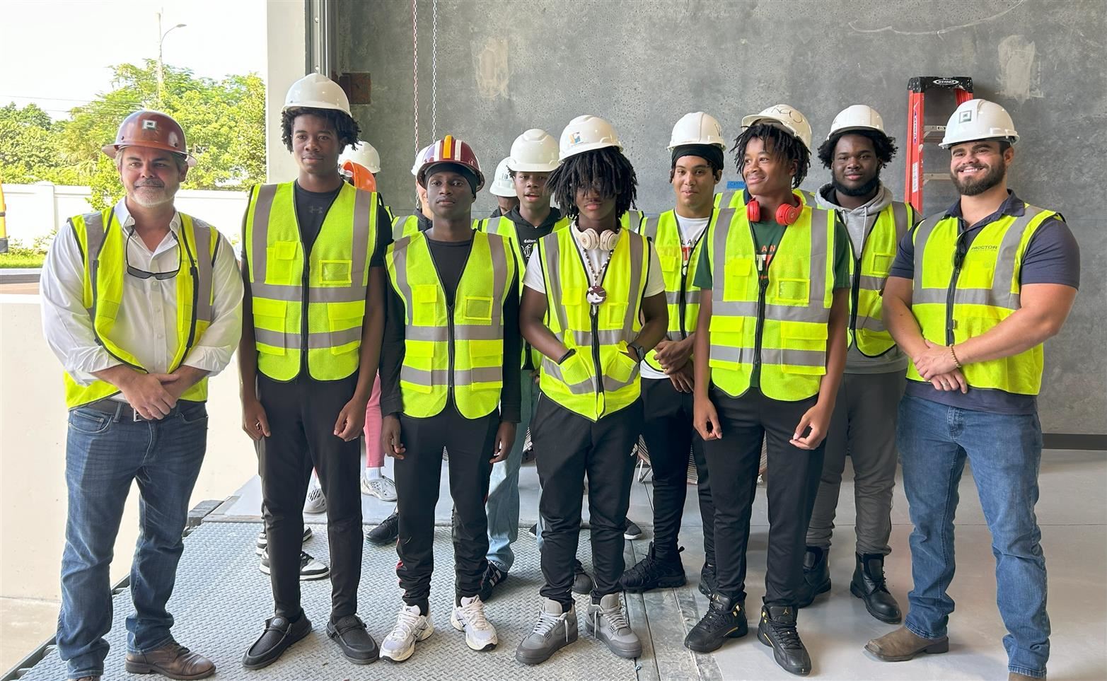  The ACHS construction students and the Proctor Construction company standing in an open bay door